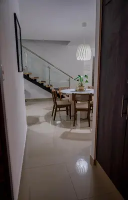 a dining room with a table and chairs and a staircase at Best Loft In The Heart of Santo Domingo Este in Juan López