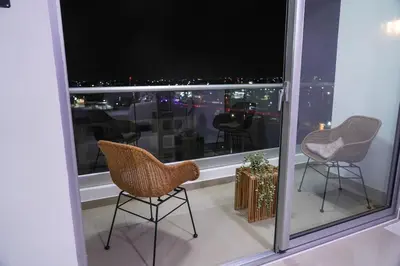 a balcony with two chairs and a view of the city at Best Loft In The Heart of Santo Domingo Este in Juan López