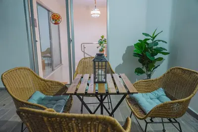 a table with wicker chairs and a table with a lamp at Best Loft In The Heart of Santo Domingo Este in Juan López