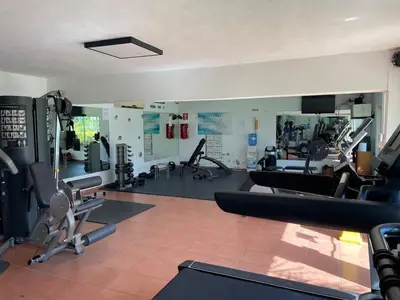a gym with several treadmills and machines in it at Oceanfront apartment with views and pool in Los Corrales