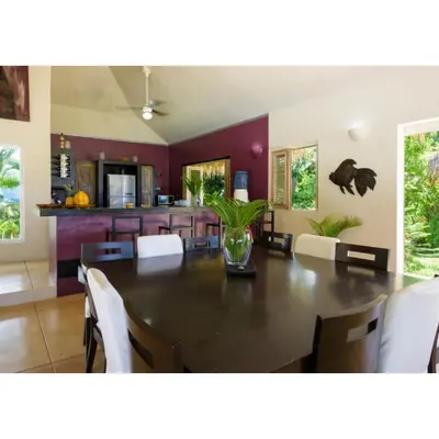 a dining room with a table and white chairs at Grandi spazi vista mare piscina infinity con grotta taina in Las Terrenas