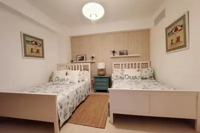 a bedroom with two beds and a lamp in it at Beach Front Condo!