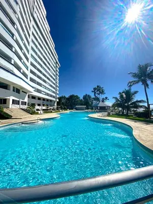 a large swimming pool in front of a building at Beach Front Condo!