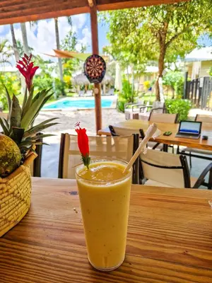a glass of orange juice sitting on a table at Hotel Enjoy in Las Terrenas