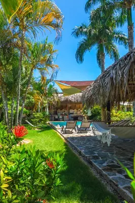 a resort with a swimming pool and palm trees at Hotel Enjoy in Las Terrenas