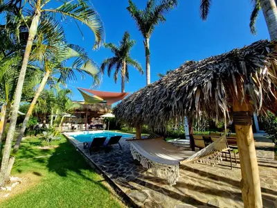 a resort with a hammock and a swimming pool at Hotel Enjoy in Las Terrenas