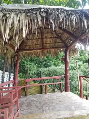 a pavilion with a bench and a straw roof at Mirador de las Nubes in Jarabacoa