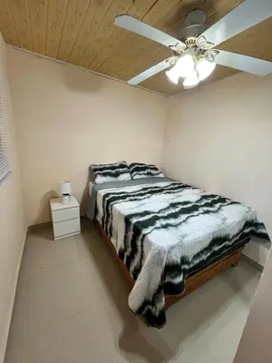 a bedroom with a bed with a ceiling fan at Mirador de las Nubes in Jarabacoa