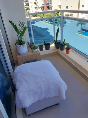 a white furry ottoman sitting on a balcony with plants at Garden view paradise in Concepción de La Vega