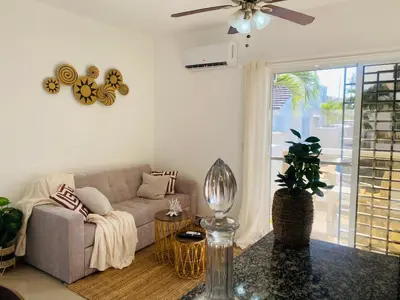 a living room with a couch and a ceiling fan at Residencial Larimar 1 - Steps from Bayahíbe Beach in Bayahibe