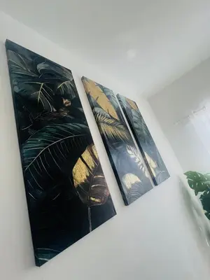 three paintings hanging on a wall in a room at Residencial Larimar 1 - Steps from Bayahíbe Beach in Bayahibe