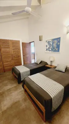 a bedroom with three beds and a ceiling fan at Villa Exceptional location - Las Ballenas in Las Terrenas