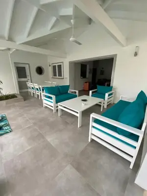 a living room with blue and white chairs and a table at Villa Exceptional location - Las Ballenas in Las Terrenas