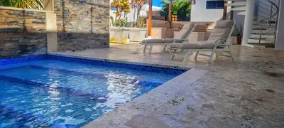a swimming pool with chairs in a house at Apt Jasmine Ocean Village in Sosúa
