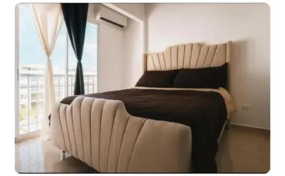 a bedroom with a large bed with a large window at Apartamento cerca del aeropuerto y la playa in San Isidro