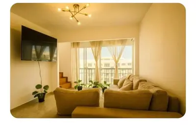 a living room with a couch and a window at Apartamento cerca del aeropuerto y la playa in San Isidro