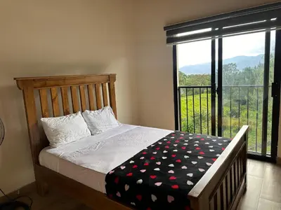 a bedroom with a bed and a large window at La Gloria in San José de Ocoa