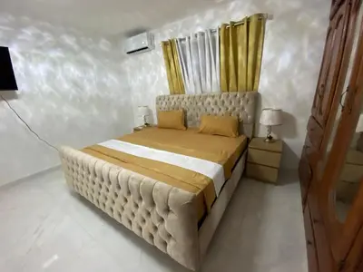 a bedroom with a large bed with yellow curtains at Enjoy Huge 4 bedrooms, and 3 bathrooms, 8 new apartments in Santiago de los Caballeros