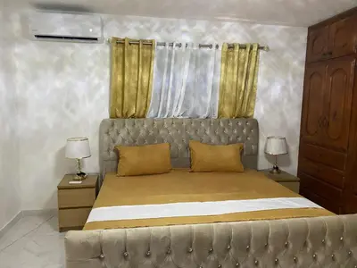 a bedroom with a large bed with gold curtains at Enjoy Huge 4 bedrooms, and 3 bathrooms, 8 new apartments in Santiago de los Caballeros