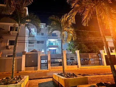 two palm trees in front of a building at night at Enjoy Huge 4 bedrooms and 3 bathrooms in Santiago de los Caballeros