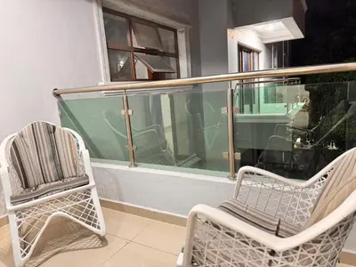 two chairs and a window on a balcony at Enjoy Huge 4 bedrooms and 3 bathrooms in Santiago de los Caballeros