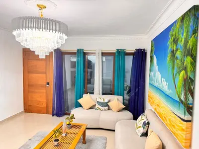 a living room with a couch and a chandelier at NEW 8apts enjoy HUGE 4 bedrs in Santiago de los Caballeros