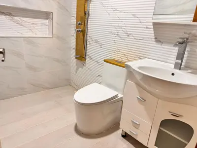 a bathroom with a white toilet and a sink at NEW 8apts enjoy HUGE 4 bedrs in Santiago de los Caballeros