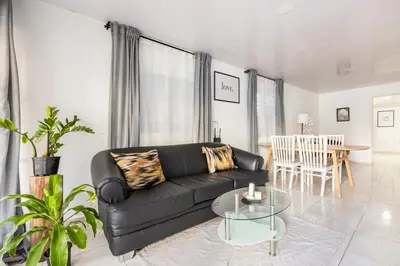 a living room with a black couch and a table at Casa de las Mariposas - near the beach in Río San Juan