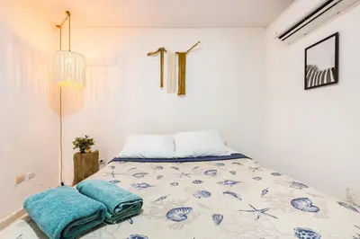a bedroom with a bed with blue pillows on it at Casa de las Mariposas - near the beach in Río San Juan