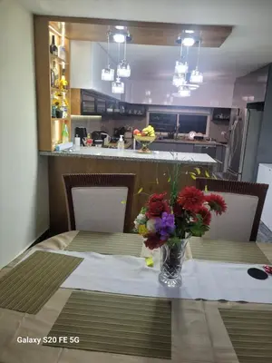 a dining room table with a vase of flowers on it at bienvenido a casa in San Pedro de Macorís
