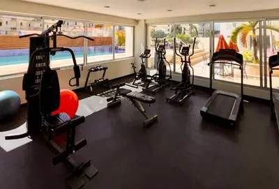 a gym with several exercise bikes and a swimming pool at MarMary Ocean view by Marina in Boca Chica