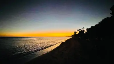 a sunset on a beach with the ocean at beach apartment cafe del sol in La Puntica de Juan Dolio