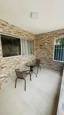a patio with two chairs and a table and two windows at beach apartment cafe del sol in La Puntica de Juan Dolio
