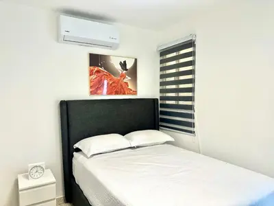 a bedroom with a bed with a black headboard at Mini Hogar Céntrico in Santiago de los Caballeros