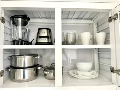 a kitchen cabinet filled with dishes and appliances at Mini Hogar Céntrico in Santiago de los Caballeros