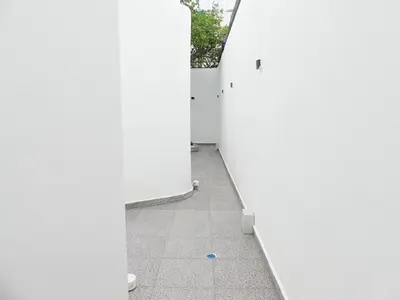 a hallway with white walls and a tile floor at Mini Hogar Céntrico in Santiago de los Caballeros
