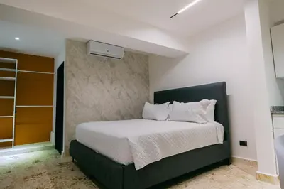 a bedroom with a bed with a black headboard at Arena Aparta Hotel in Punta Cana