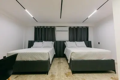 two beds sitting next to each other in a room at Arena Aparta Hotel in Punta Cana