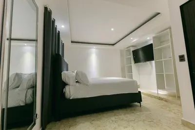 a bedroom with a bed and a mirror at Arena Aparta Hotel in Punta Cana
