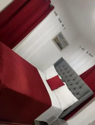 a red and white bed in a white bedroom at Apartamento Alto del valle de 2 habitaciones in Santiago de los Caballeros
