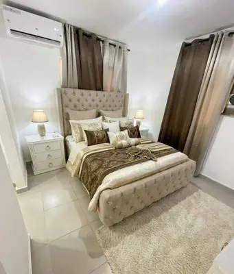a bedroom with a large bed and a night stand at Beautifull and Luxe Apartment 10 mn to the Int Airport in Los Paredones