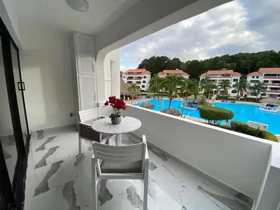 a balcony with a table and a view of a pool at Crystal Pool Oasis in Sosúa