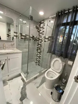 a bathroom with a toilet and a glass shower at Crystal Pool Oasis in Sosúa