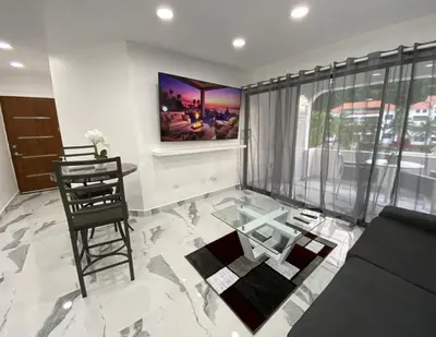 a living room with a glass table and a chair at Crystal Pool Oasis in Sosúa