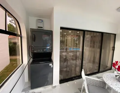 a screened in porch with a television and a table at Crystal Pool Oasis in Sosúa