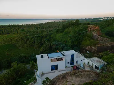 a white house on top of a hill with the ocean at Villas Escape in Las Terrenas