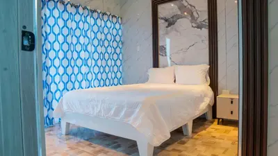 a bedroom with a white bed with a blue patterned wall at Villas Escape in Las Terrenas