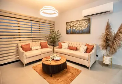 a living room with two couches and a table at Hermoso Alojamiento con Terraza y Jacuzzi en Santiago in Santiago de los Caballeros