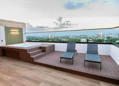 a balcony with a hot tub and two chairs at Hermoso Alojamiento con Terraza y Jacuzzi en Santiago in Santiago de los Caballeros