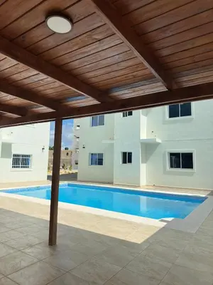 a swimming pool under a wooden pergola at Luxury Apartment in Boca Chica in La Julia